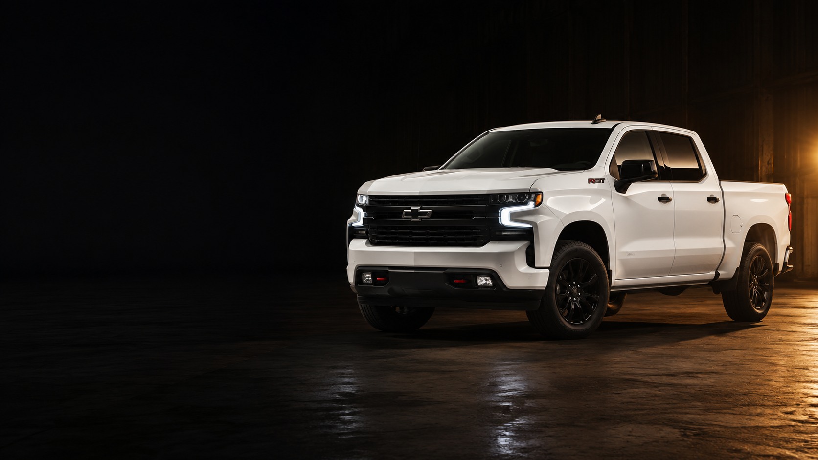 Chevrolet Silverado 2025 blanca iluminada en un entorno industrial